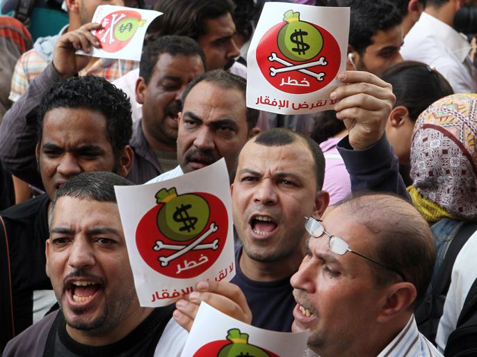 epa03648636 Egyptian protesters hold placards with Arabic inscription reading ‘danger’ and shout slogans as they protest against the International Monetary Fund (IMF) delegation visit, in front of the General-Prosecutor's office in Cairo, Egypt, 03 April 2013. Media reports on 03 April state Egypt and an IMF delegation will negotiate a much-needed 4.8-billion-dollar loan to revitalize an economy battered by political upheaval and strikes. EPA/KHALED ELFIQI