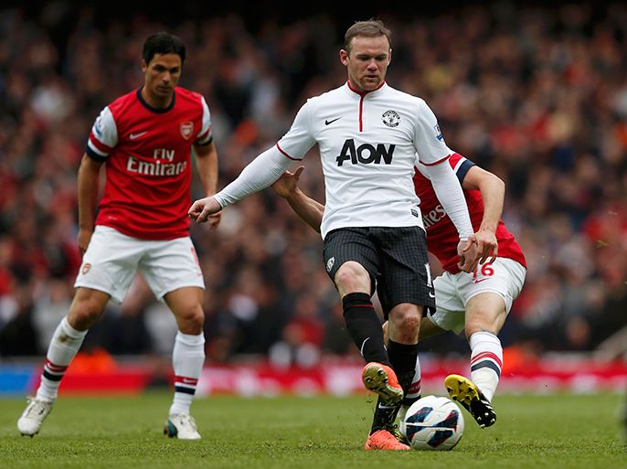Manchester United's Wayne Rooney (C) is challenged by Arsenal's Aaron Ramsey during their English Premier League soccer match at Emirates Stadium in north London April 28, 2013. REUTERS/Eddie Keogh (BRITAIN - Tags: SPORT SOCCER) EDITORIAL USE ONLY. NO USE WITH UNAUTHORIZED AUDIO, VIDEO, DATA, FIXTURE LISTS, CLUB/LEAGUE LOGOS OR 'LIVE' SERVICES. ONLINE IN-MATCH USE LIMITED TO 45 IMAGES, NO VIDEO EMULATION. NO USE IN BETTING, GAMES OR SINGLE CLUB/LEAGUE/PLAYER PUBLICATIONS.