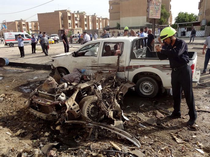 epa03662928 An Iraqi policeman inspects the site of a car bomb attack in Kirkuk, northern Iraq, 15 April 2013. Media reports state that at least 20 people were killed and 182 others were wounded in a series of car bombings and shootings across Iraq. EPA/KHALIL AL-A'NEI
