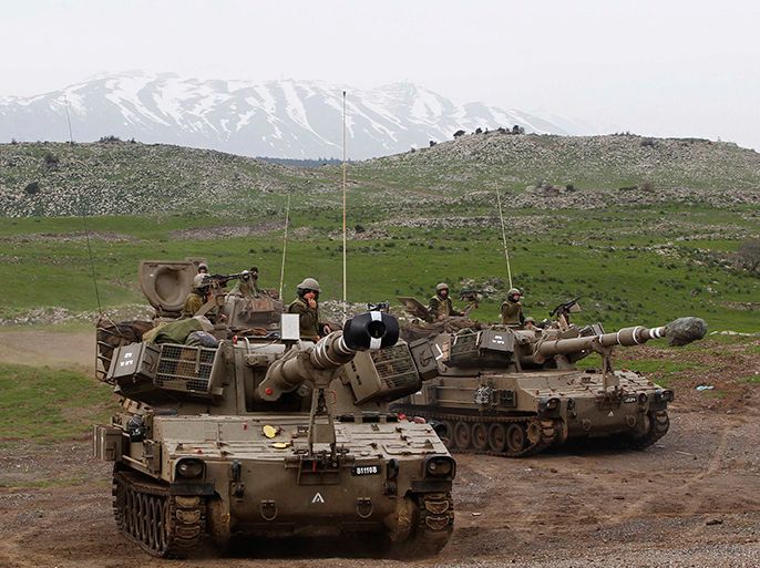 Mount Hermon is seen in the background as Israeli soldiers travel on mobile artillery units after an exercise on the Israeli occupied Golan Heights, close to the ceasefire line between Israel and Syria in this February 14, 2013 file photo. Israel is worried that the Golan, which it captured from Syria in 1967, will become a springboard for attacks on Israelis by jihadi fighters, who are taking part in the armed struggle against Syrian President Bashar al-Assad.