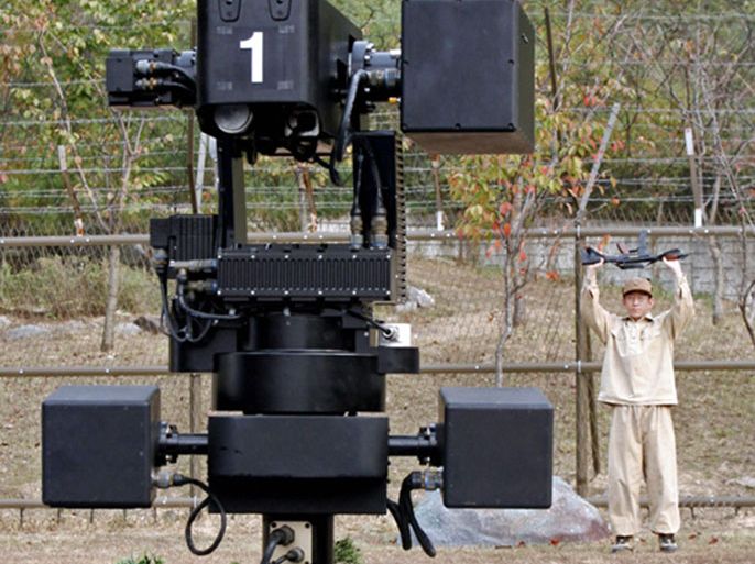 The South Korean SGR-1 sentry robot, a precursor to a fully autonomous weapon, can detect people in the Demilitarized Zone and, if a human grants the command, fire its weapons. The robot is shown here during a test with a surrendering enemy soldier.