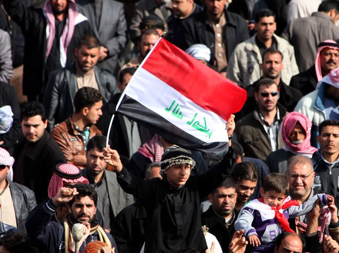 epa03553820 Iraqi Sunni protesters chant slogans and carry the national flag during an anti-government demonstration in Ramadi city, western Iraq, 24 January 2013. Iraqi Sunni protesters are asking the government to amend the anti-terrorism law and the release of tens of thousands of prisoners and cancel the law against members of the former Baath party. EPA/MOHAMMED JALIL