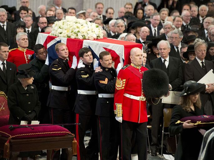 Britain's Queen Elizabeth II (L) and Mark Thatcher (R), Margaret Thatcher's son, watch the Bearer Party made up of personnel from the three branches of the military carry the coffin of British former prime minister Margaret Thatcher during her ceremonial funeral in St Paul's Cathedral in central London on April 17, 2013. The funeral of Margaret Thatcher took place on April 17, with Queen Elizabeth II leading mourners from around the world in bidding farewell to one of Britain's most influential and divisive prime ministers. AFP PHOTO / POOL / PAUL EDWARDS