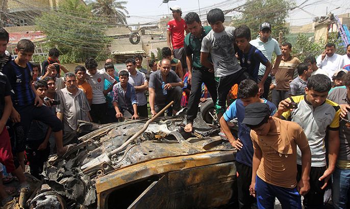 Iraqis inspect the site of a car bombing at a market in Baghdad's impoverished district of Sadr City on May 16, 2013 as at least eight people were killed in blasts across the country.