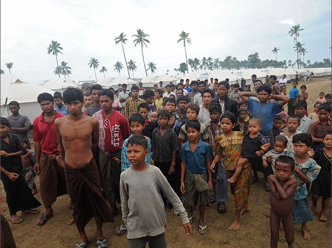 Displaced Rohingyas gather outside their tents at the Mansi Internally Displaced Persons (IDP) camp on the outskirts of Sittwe on May 15, 2013. Hundreds of thousands of people in Bangladesh and Myanmar were ordered to evacuate Wednesday as a cyclone bore down on coastal areas home to flood-prone refugee camps for victims of sectarian unrest. AFP PHOTO / SOE THAN WIN