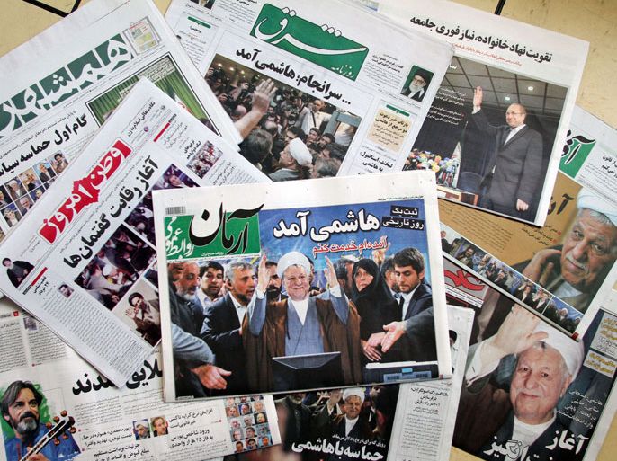 AK002 - Tehran, -, IRAN : A selection of daily Iranian newspapers mainly fronted by an image of Iran's former president Akbar Hashemi Rafsanjani, are seen on May 12, 2013, in Tehran. Rafsanjani who registered for next month's presidential election, is disliked among regime hardliners for criticising the crackdown that followed Mahmoud Ahmadinejad's disputed re-election in 2009. AFP PHOTO/ATTA KENARE