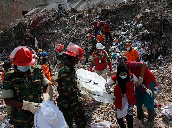 Rescue workers carry the remains of a garment worker retrieved from the rubble of the collapsed Rana Plaza building in Savar, 30 km (19 miles) outside Dhaka May 3, 2013. Police investigating the collapse of a Bangladesh factory building that killed more than 500 people have arrested an engineer who warned the day before that the eight-storey complex was unsafe. REUTERS/Andrew Biraj (BANGLADESH - Tags: DISASTER) BUSINESS EMPLOYMENT) TEMPLATE OUT