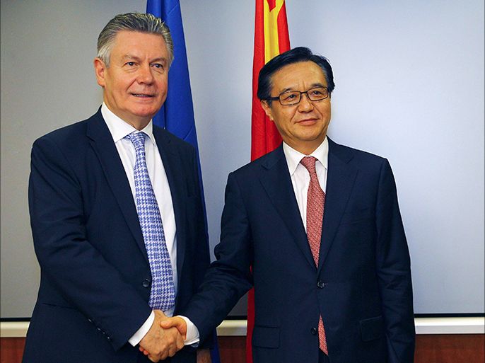 Chinese Commerce Minister Gao Hucheng (R) shakes hands with European Union Trade Commissioner Karel de Gucht in front of national flags of China (back R) and the European Union during a meeting at the Chinese Ministry of Commerce in Beijing, June 21, 2013. REUTERS/China Daily (CHINA - Tags: BUSINESS POLITICS) CHINA OUT. NO COMMERCIAL OR EDITORIAL SALES IN CHINA