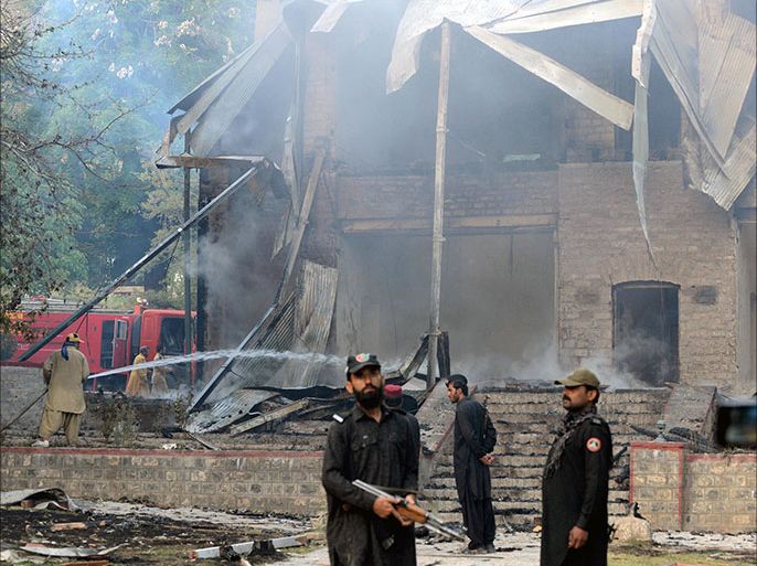Pakistani security personnel look on as firefighters extinguish a blaze which gutted a historical building in Ziarat, 80 kilometres southeast of Quetta, on June 15, 2013. Militants blew up a historic building in violence-plagued southwest Pakistan after shooting dead a guard in a predawn attack on June 15, officials said. The country's founding father Mohammad Ali Jinnah spent his last days in the building, which was declared a national monument following his death, one year after Pakistan's independence in 1947. AFP PHOTO/Banaras KHAN