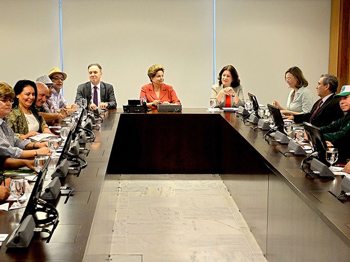 Brazilian President Dilma Rousseff (C), Minister of Cities Agnaldo Ribeiro (C-L) and Planning Minister Miriam Belchior (C-R) are seen during a meeting with leaders of urban social movements at Planalto Palace in Brasilia in June 25, 2013. Rousseff is meeting with leaders from several sectors of society to discuss proposals submitted yesterday to governors. AFP PHOTO/Evaristo Sa