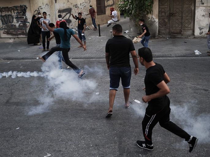 Bahraini protestors run for cover from tear gas and bird shots fired by riot police during clashes following an a protest to demand more rights and against the ruling regime in the village of Bilad al-Qadeem, in a suburb of Manama, on June 15, 2013. Weekly protests, that began in 2011, are held by Bahraini Shiite Muslims demanding more rights from the ruling Sunni Muslim dynasty