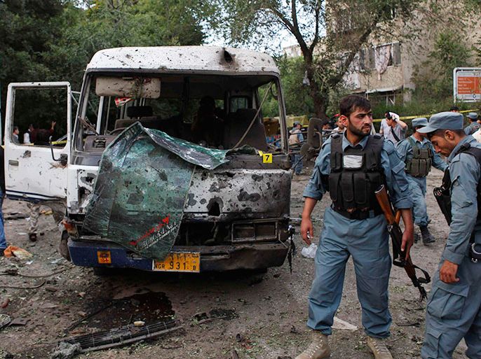 Afghan policemen stand at the site of a suicide car bomb attack in Kabul June 11, 2013. A bomb exploded on Tuesday near minibuses taking Supreme Court staff home in the Afghan capital, Kabul, killing at least eight people and wounding dozens, police said. REUTERS/Mohammad Ismail (AFGHANISTAN - Tags: CIVIL UNREST)