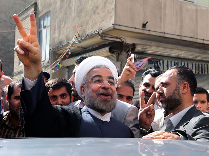 )-Taken on June 14, 2013, Iranian moderate presidential candidate, Hassan Rowhani (C) flashes the sign of victory as he leaves a polling station after voting on in Tehran during the first round of the presidential candidate. Rowhani has won Iran's presidential election, the interior minister announced on June 15, 2013, putting an end to eight years of conservative grip on the nation's executive. AFP PHOTO/ATTA KENARE