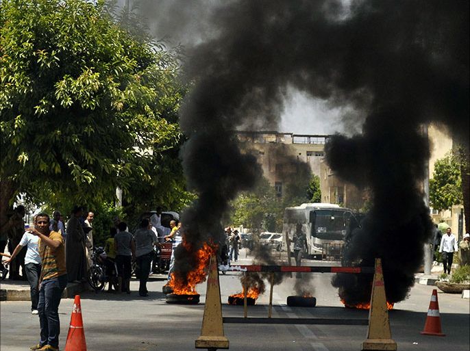 Protesters burn tyres in front of the Luxor governorate building to protest against the newly-appointed governor, Adel Mohamed al-Khayat, who was a member of the militant group, al-Gamaa al-Islamiya, in Luxor June 19, 2013. Al-Khayat was a member of the militant group blamed for slaughtering 58 tourists in Egypt's Valley of the Queens; today he's promising to keep visitors safe. Khayat's appointment by President Mohamed Mursi as governor of the city of Luxor has triggered howls of protest, with demonstrators protesting for a third day on Wednesday and one critic calling it "the last nail in the coffin of tourism". REUTERS/Stringer (EGYPT - Tags: POLITICS CIVIL UNREST)