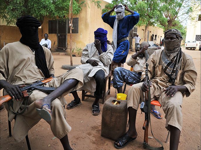 (FILES) -- A file photo taken on July 16, 2012 shows fighters of the Islamist group Movement for Oneness and Jihad in West Africa (MUJAO) sitting in the courtyard of the Islamist police station in Gao. Renewed abuses by ethnic Tuareg rebels and Malian army soldiers are a step backward for human rights protection in northern Mali, Human Rights Watch said on June 7, 2013. On June 5, 2013, army forces began a military offensive to recapture the Kidal region. AFP PHOTO / ISSOUF SANOGO