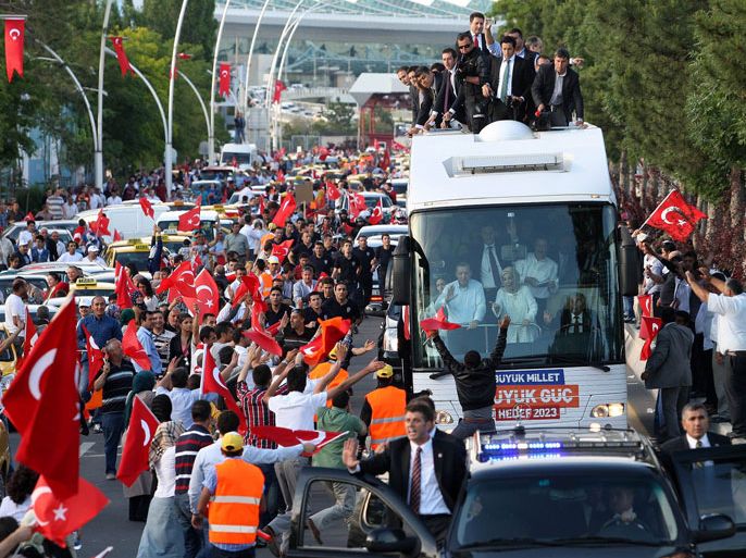 Turkish Prime Minister Recep Tayyip Erdogan (at left in bus) and his wife Emine wave to supporters on their arrival in Ankara on June 9, 2013. Erdogan warned today that the patience of his Islamic-rooted government "has a limit" as mass protests against his decade-long rule raged for a 10th day
