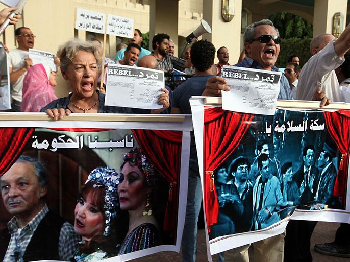 epa03724073 Egyptian intellectuals hold posters and the Tamarod (Rebellion) petitions while chanting slogans during demonstration against Minister of Culture Alaa Abdel Aziz, in front of opera house Cairo, Egypt, 30 May 2013. A group of intellectuals and artists gathered to protest against the minister for his latest decision to sack the Cairo Opera House's president Inas Abdel Dayem. EPA/KHALED ELFIQI