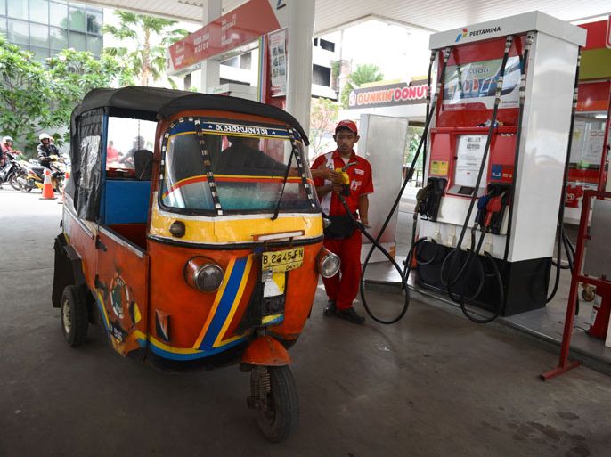 INDONESIA : A bajaj, traditional Indonesian transport vehicle, fills up at a Pertamina fuel station, a state-owned petroleum company in Jakarta on June 18, 2013 where premium fuel sells for 0.46 USD per liter. Indonesia defied popular anger by pressing ahead with its first fuel price hike since 2008, a day after police fought running battles with thousands outside parliament. Lawmakers approved measures on June 17, 2013 paving the way for a reduction in crippling fuel subsidies in Southeast Asia's top economy. AFP PHOTO