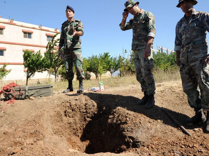 JE01 - Baalbek, -, LEBANON : Lebanese soldiers inspect the crater caused by a rocket fired from Syria that hit Lebanon's eastern city of Baalbeck on June 6, 2013. At least five rockets launched from across Lebanon's border with Syria hit Baalbek on June 5, 2013, including two that landed near the city's renowned Roman ruins, a security source told AFP. AFP PHOTO STR