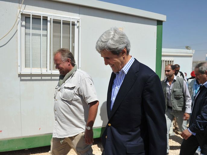 ZAATARI REFUGEE CAMP, -, JORDAN : US Secretary of State John Kerry (C) tours the Zaatari refugee camp with camp manager Kilian Kleinschmidt (L) near the Jordanian city of Mafraq on July 18, 2013. Kerry visited the sprawling Zaatari camp home to tens of thousands of Syrian refugees to see at first-hand the tragedy of the conflict. Kerry first overflew the vast camp by helicopter, surveying hundreds of tents and trailers lined up on the desert sand about 20 kms (12.4 miles) from the Syrian border. AFP PHOTO/POOL/MANDEL NGAN