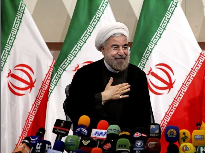 FILE - In this Monday, June 17, 2013 file photo, Iranian President-elect Hasan Rouhani, places his hand on his heart as a sign of respect, after speaking at a news conference, in Tehran, Iran. Rouhani on Monday leveled his first criticism of the outgoing administration since June's election, saying it has mismanaged the country's economy.