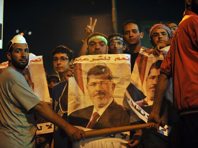 FN202 - Cairo, -, EGYPT : Egyptian supporters of the deposed president Mohamed Morsi protest (portrait) during a demonstration against the government at al-Nasr street in Cairo on July 30, 2013, Tense Egypt braced for a showdown in the streets between supporters of Morsi and his army-backed opponents, who have called for demonstrations acrossEgypt. AFP PHOTO/FAYEZ NURELDINE
