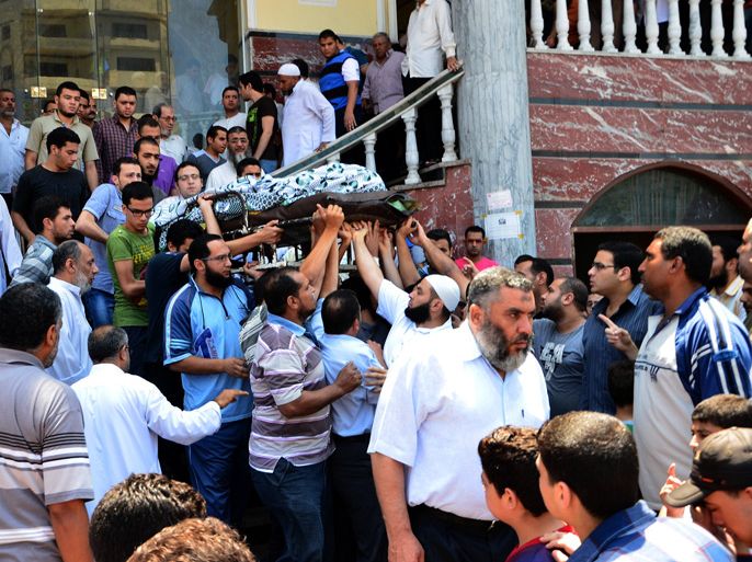 Egyptian people carry the body of a victim of the clashes that broke out between supporters and opponents of Egypt's depose president Mohamed Morsi during a funeral ceremony on July 20, 2013 in the Nile delta city of Mansura. The clashes broke out overnight in Mansura, killing 3 people, during a rally of supporters of the Muslim Brotherhood to demand the army to restore Morsi after he was toppled in a popularly backed coup.
