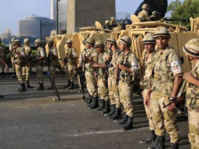 Egyptian army soldiers take their positions near armored vehicles to guard the entrances of Tahrir square, in Cairo, Egypt, Monday, July 8, 2013. Egyptian military officials said gunmen killed at least five supporters of the former president when people tried to storm a military building in Cairo. The official, who declined to be named because he was not authorized to brief reporters, also said a group had tried to storm the headquarters of the Republican Guard. He added that those killed had been supporters of former President Mohammed Morsi camped outside the building in protest at his overthrow.