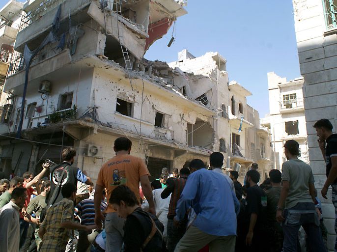 JAH02 - Aleppo, -, SYRIA : Rescuers and neighboors gather at the scene after a rocketed slammed into the side of a residential building in the northern city of Aleppo, on June 29, 2013. Relief organisations in war-torn Syria are unable to keep pace with the ever-growing suffering of tens of thousands of victims despite dramatic increases in aid, the Red Cross said on June 27. AFP PHOTO/JALAL-ALHALABI