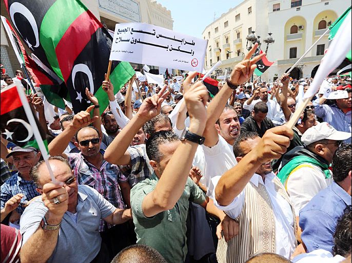 Libyan protesters shout slogans waving national flags during a demonstration on the Algeria Square to demand the removal of arms and the evacuation of unofficial armed groups and the implementation of the General National Congress (GNC)'s decision on July 7, 2013 in the Libyan capital Tripoli. The GNC, the country's highest political authority, announced last June his decision to remove "illegal militias" from the capital after deadly fightings that highlighted the lack of security nearly two years after dictator Moamer Kadhafi fell. AFP PHOTO MAHMUD TURKIA