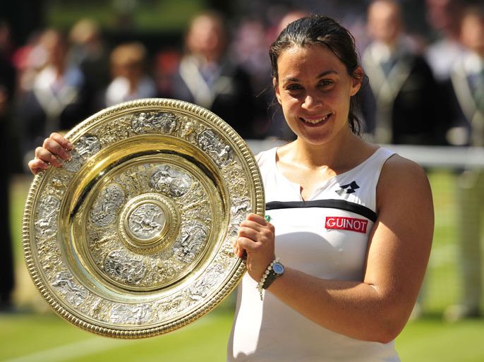 France's Marion Bartoli poses with the winner's Venus Rosewater Dish after beating Germany's Sabine Lisicki in their women's singles final match on day twelve of the 2013 Wimbledon Championships tennis tournament at the All England Club in Wimbledon, southwest London, on July 6, 2013. Bartoli won 6-1, 6-4. AFP PHOTO / GLYN KIRK - RESTRICTED TO EDITORIAL USE