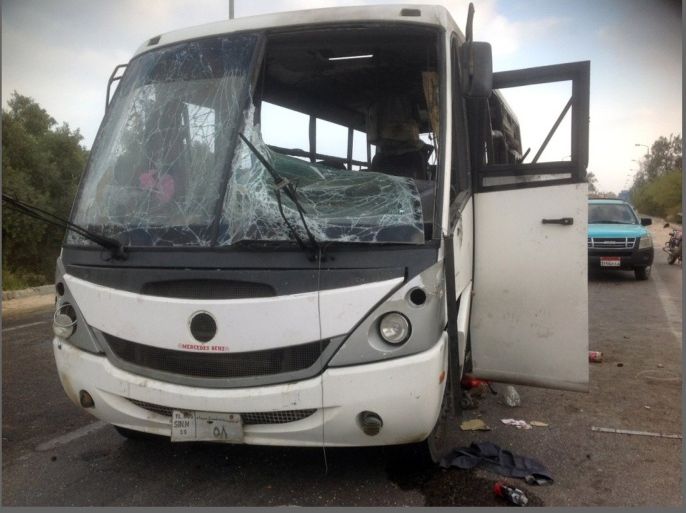 Egyptians inspect the site of an attack by militants on a bus carrying workers in the North Sinai town of Al-Arish, on July 15, 2013. The bus was targeted with a rocket-propelled grenade and left at least three people dead and 17 wounded, according to a security official.