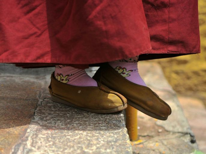 epa02748968 Tibetan nun wears a pair of socks with a cartoon character motif at Tsamkhung Nunnery in downtown Lhasa city, Tibet, 24 May 2011. The Tsamkhung Nunnery is located in the southeast of Jokhang temple and is the only nunnery established in the old seventh century Lhasa city. Tibetan king Songtsan Gampo meditated in a natural cave at this site reciting prayers to pacify the dangers from the flood of Lhasa River. Now there are 125 nuns resident EPA/WU HONG