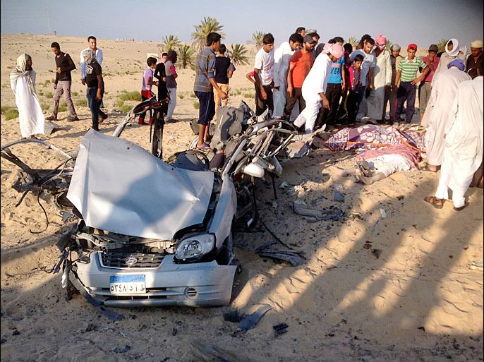 People check the scene where a car bomb exploded in near the port town of El-Arish in Egypt's Sinai peninsula July 24, 2013. A car bomb exploded near a police base and two soldiers were killed in separate, multiple attacks in Egypt's lawless Sinai peninsula, which has seen a spike in violence since the July 3 army ouster of the country's Islamist president. Four militants died when the car, rigged with gas canisters and carrying explosive belts, detonated in a desert area near the port town of El-Arish on Wednesday, the sources said. REUTERS/Stringer (EGYPT - Tags: POLITICS CIVIL UNREST)