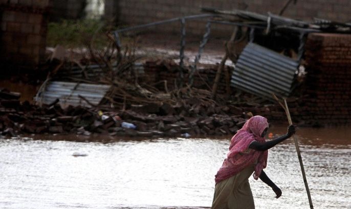 A Sudanese woman makes her way through flood water in Khartoum, Sudan, Tuesday, Aug. 6, 2013. Floods that hit different areas in Sudan this week have lead to destructions of hundreds of homes, death of scores and dozens injured.