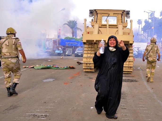 An Egyptian woman shouts as security forces move in with a bulldozer to clear one of the two sit-in sites of supporters of ousted president Morsi, at Nahda square, near Cairo University, Cairo, Egypt, 14 August 2013. According to local media reports, one soldier and dozens of protesters were killed and about 200 others arrested as Egyptian security forces began clearing islamist protest camps in the capital Cairo on 14 August. The military-backed government described the protest camps as violent and unlawful. The biggest sit-ins are in north-eastern Cairo and south of the capital.