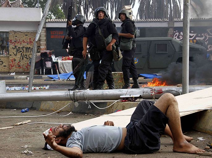An injured man lies on the ground as Egyptian security forces move in to disperse a protest camp held by supporters of ousted president Mohamed Morsi and members of the Muslim Brotherhood, on August 14, 2013 near Cairo's Rabaa al-Adawiya mosque. Egypt's Muslim Brotherhood said at least 250 people were killed and over 5,000 injured in a police crackdown. AFP PHOTO/STR