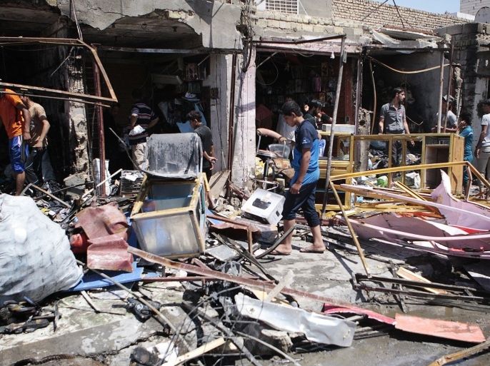 Residents inspect the site of a car bomb attack in Basra, 420 km (260 miles) southeast of Baghdad, July 29, 2013. One car bomb went off in a busy popular market north of the southern oil hub city of Basra on Monday, killing at least two civilians and wounding 10 others, police and medical sources said.