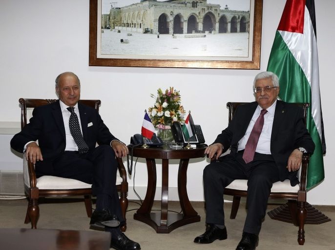 Palestinian President Mahmoud Abbas (R) and France's Foreign Minister Laurent Fabius are seen at the start of their meeting in the West Bank city of Ramallah August 24, 2013.