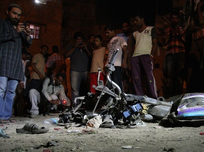 Local residents gather at the site of a bomb explosion in the Pakistani port city of Karachi early on August 7, 2013. The bomb blast in Pakistan's port city of Karachi early on August 7 killed seven people and wounded 26 others, police said. The blast took place in the impoverished Lyari neighbourhood of the city after a football match.