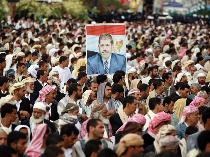 Yemeni protesters gather in solidarity with the Muslim Brotherhood and ousted Egyptian president Mohammed Morsi (portrait) in a rally in Sanaa on August 16, 2013. Four supporters of ousted president Mohamed Morsi and one policeman were killed in Egypt on August 16, as clashes erupted in several cities between Islamist protesters and security forces. AFP PHOTO/ MOHAMMED HUWAIS