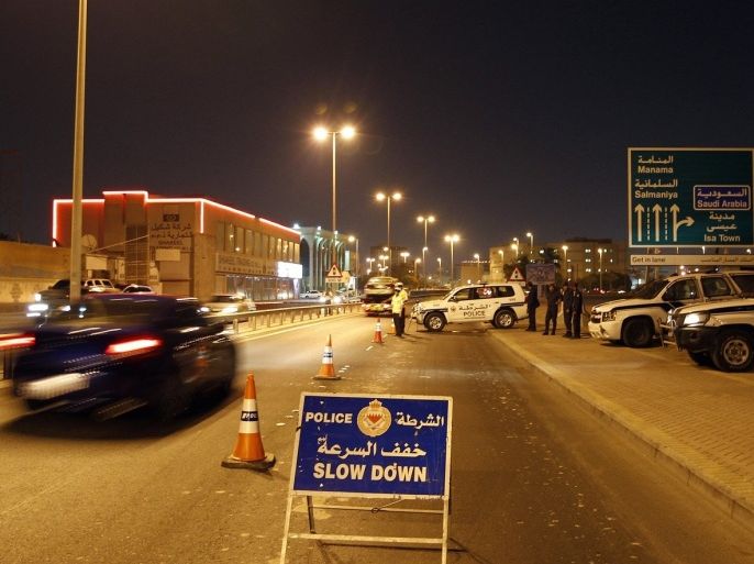 Members of police stand at a security checkpoint set up on a road leading out of Bilad al-Qadeem village during the early hours of the evening in Manama August 13, 2013. Bahrain has increased its security with checkpoints in various areas especially around Shi'ite villages, such as Bilad al-Qadeem, as the opposition called for a massive anti-government protest on Wednesday. Bahrain's prime minister said on Monday his government would "forcefully confront" protests called for later this week, and warned those behind planned demonstrations that they would be punished, state news agency BNA reported. August 14 marks the day in 1971 when Bahrain gained independence from Britain.
