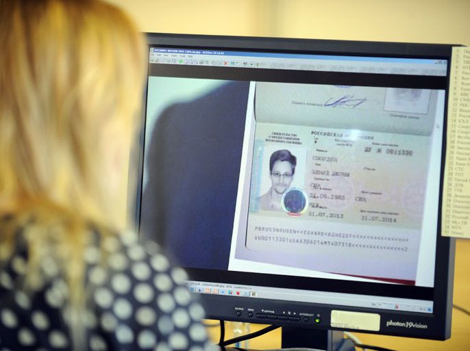 RUSSIAN FEDERATION : A woman watches a footage on her computer, showing the lawyer of fugitive US intelligence leaker Edward Snowden showing his client's one year's asylum permit at Sheremetyevo airport in Moscow on August 1, 2013. Edward Snowden, the US intelligence leaker who left a Moscow airport Thursday after winning asylum in Russia, will be helped in his new country of residence by "American friends," his lawyer said. "I can open up the curtain a little. Of course he has acquired friends in Russia, American friends, who can ensure his security for some time