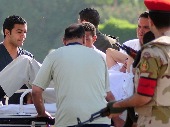 Egyptian security forces and medics wheel a stretcher transporting former Egyptian president Hosni Mubarak from a military helicopter into an ambulance on August 22, 2013 at a Cairo military hospital after his release from prison. Mubarak was flown from prison by helicopter to a military hospital after he was cleared for conditional release while standing trial, an interior ministry general told AFP. He will be held under house arrest at the Cairo hospital on the orders of the prime minister, who has been granted the power to order arrests during the current state of emergency.