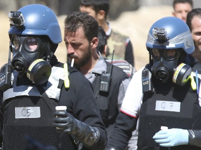 U.N. chemical weapons experts wearing gas masks carry samples from one of the sites of an alleged chemical weapons attack in the Ain Tarma neighbourhood of Damascus August 28, 2013. U.N. chemical weapons experts investigating an apparent gas attack that killed hundreds of civilians in rebel-held suburbs of Damascus made a second trip across the front line to take samples.