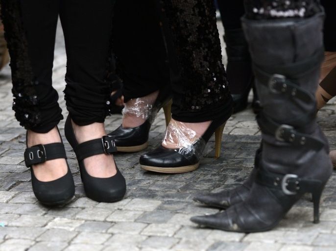 High-heels are taped onto feet of candidates prior to the start of the ''High-heel run' competition in Prague, Czech Republic, on April 29, 2013.