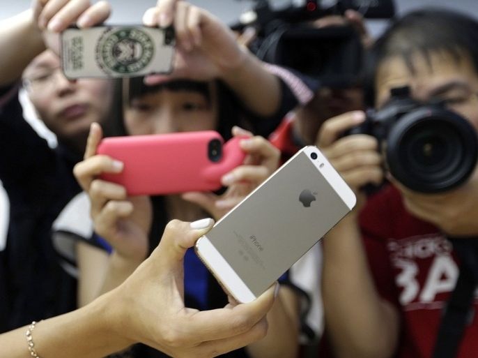 Journalists take photos of a new iPhone 5S during Apple Inc's announcement event in Beijing, September 11, 2013. Apple Inc's millions of Chinese fans will celebrate the near-simultaneous launch of the latest iPhone in China and the United States, but one group will have little to cheer - the smugglers. An early launch of Apple's latest smartphone in China is expected to stifle a thriving grey market worth billions of dollars a year built around smuggling from Hong Kong, where in the past the U.S. tech giant's gadgets have gone on sale months before they reach official channels in the mainland.