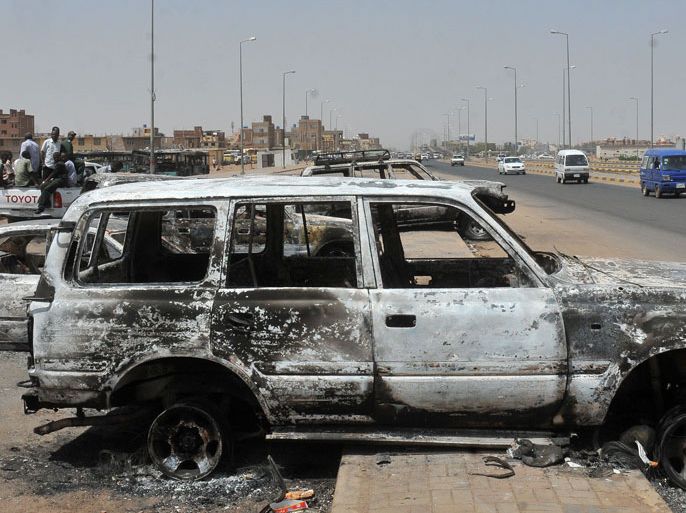 A picture taken on September 26, 2013 shows burnt vehicles in a street of the Sudanese capital Khartoum after rioting erupted following a decision of the government to scrap fuel subsidies. On September 25, a hospital source in Khartoum's twin city of Omdurman told AFP that "we have received the bodies of 21 people" since the protests first broke out, adding that all were "civilians". AFP PHOTO /STR
