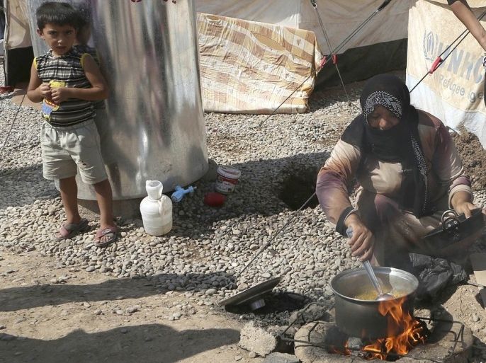 A Syrian refugee cooks food near her tent at Kawergost refugee camp in Irbil, 217 miles (350 kilometers) north of Baghdad, Iraq, Sunday, Sept. 22, 2013. The humanitarian needs in Syria are staggering. An estimated 6.8 million Syrians require assistance, a number equal to the population of Vermont, New Hampshire, Maine and Connecticut combined. Of that number, about 2 million have fled to neighboring countries. Even more somewhere between 4 and 5 million are displaced from their homes inside Syria.