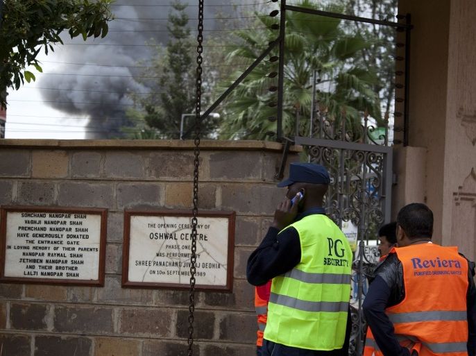 Security officers in a nearby property watch as dark smoke billows above the Westgate Mall in Nairobi, Kenya after a loud explosion Monday, Sept. 23, 2013. Multiple large blasts have rocked the mall where a hostage siege is in its third day. Associated Press reporters on the scene heard multiple blasts and a barrage of gunfire. Security forces have been attempting to rescue an unknown number of hostages inside the mall held by al-Qaida-linked terrorists.